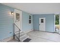 Covered entrance featuring a well-lit doorway, stairs, and neutral siding at 522 Saint Andrews Blvd, Lady Lake, FL 32159
