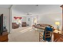 Bright living room with neutral carpet, ceiling fan, and comfortable seating at 522 Saint Andrews Blvd, Lady Lake, FL 32159