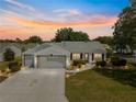 Beautiful single-story home with a three car driveway, lush landscaping, and a serene neighborhood setting at 8069 Se 174Th Ludlow Pl, The Villages, FL 32162