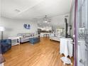 Bright living room with wood floors, ceiling fan, and a view to the kitchen at 8069 Se 174Th Ludlow Pl, The Villages, FL 32162