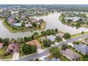 Stunning aerial view of a residential neighborhood featuring waterfront homes and mature trees around a tranquil lake at 8167 Bridgeport Bay Cir, Mount Dora, FL 32757