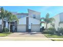Modern townhome showcases a two-car garage, brick-paved driveway, and neatly landscaped yard at 817 Ocean Course Ave # 502, Davenport, FL 33896