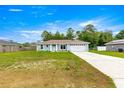 Single-story home with a well-maintained lawn and a driveway leading to an attached two-car garage at 8869 Se 159Th Pl, Summerfield, FL 34491