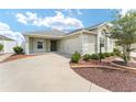 Home exterior featuring landscaped front yard, a concrete driveway and a two-car garage at 9181 Se 166Th Sprung Ln, The Villages, FL 32162