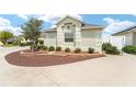 Well-maintained front yard features a decorative tree, stone accents, and tidy landscaping at 9181 Se 166Th Sprung Ln, The Villages, FL 32162