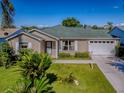 Charming single-story home with an attached garage, well-maintained lawn, and nicely landscaped front yard at 1060 Davenport Dr, The Villages, FL 32162
