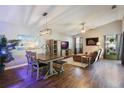 Open-concept living and dining area with wood floors, modern light fixture, and comfortable seating at 12430 Ne 52Nd Loop, Oxford, FL 34484