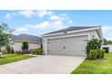 Close up of a two-car garage of a single Gathering home with well manicured landscaping at 1247 Mezzavalle Way, Auburndale, FL 33823
