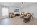 Spacious living room with neutral walls, wood-look flooring, and stylish furnishings at 1247 Mezzavalle Way, Auburndale, FL 33823