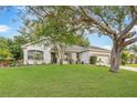 Beautiful single-story home with a lush lawn and mature trees offering great curb appeal at 13332 Via Roma Cir, Clermont, FL 34711