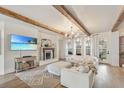 Bright living room with wood beams, fireplace, and comfortable white furniture at 13332 Via Roma Cir, Clermont, FL 34711