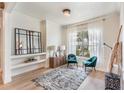 Sitting room featuring decorative mirror, comfortable teal chairs, and large bright window at 13332 Via Roma Cir, Clermont, FL 34711