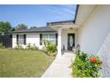 Inviting front porch with decorative columns and manicured landscaping at 14350 Se 36Th Ave, Summerfield, FL 34491