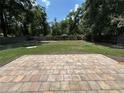 The backyard features brick pavers, a lawn, and a wooden fence, creating a private retreat at 14466 Se 45Th Ct, Summerfield, FL 34491