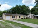 The attractive single Gathering home sits on a green lawn with a concrete driveway and mature trees at 14466 Se 45Th Ct, Summerfield, FL 34491