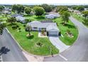 Aerial view of a well-maintained home with lush lawn, mature trees, and a circular driveway in a quiet neighborhood at 17819 Se 105Th Ct, Summerfield, FL 34491