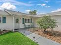 Cozy front porch with rocking chairs, charming landscaping, and a welcoming entrance at 17819 Se 105Th Ct, Summerfield, FL 34491