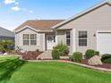 The front of the home features tidy landscaping, a white door, and neutral siding at 17916 Se 87Th Melrose Ct, The Villages, FL 32162