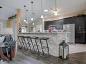 Stylish kitchen featuring a breakfast bar, modern pendant lighting, and stainless steel appliances at 1914 Armondo Dr, The Villages, FL 32159