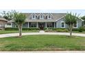 Lovely home with a circular driveway, manicured lawn, and inviting front porch at 19624 Spring Oak Dr, Eustis, FL 32736