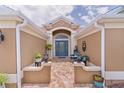 Inviting front entrance with a blue glass door, brick pavers and manicured landscaping at 1972 Palo Alto Ave, The Villages, FL 32159