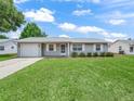 Attractive single-story home with a well-maintained lawn, attached garage, and a clean exterior at 2242 Orkney Dr, Leesburg, FL 34788