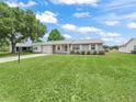 Inviting single-story home showcasing a lush front lawn, an attached garage and a tidy exterior at 2242 Orkney Dr, Leesburg, FL 34788