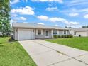Classic single-story home boasting a well-kept lawn, attached garage, and a tidy exterior at 2242 Orkney Dr, Leesburg, FL 34788