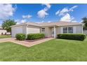 Inviting front entrance with manicured bushes and a well maintained lawn at 2369 Five Forks Trl, The Villages, FL 32162