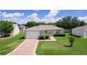 Charming single-story home featuring a well-manicured lawn and attached one car garage at 2369 Five Forks Trl, The Villages, FL 32162