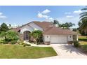 Well-maintained home with a two-car garage, beautiful landscaping, and a lovely pathway to the front door at 2457 Bar Harbor, Mount Dora, FL 32757