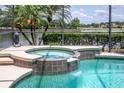A relaxing hot tub next to the screen enclosed pool, offering a perfect spot to unwind and enjoy the water view at 2457 Bar Harbor, Mount Dora, FL 32757