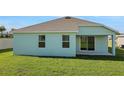 Large grassy backyard featuring a covered patio and well-maintained lawn at 2860 Supermarine Rd, Tavares, FL 32778