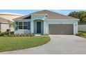 Charming single-story home with a well-manicured lawn and attached one car garage at 2860 Supermarine Rd, Tavares, FL 32778