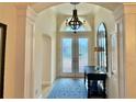 Elegant foyer with soaring ceilings, decorative chandelier, and double doors at 2918 Canyon Ave, The Villages, FL 32163