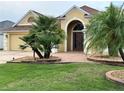 Inviting home with lush landscaping, a brick walkway, and a double-door entry at 2918 Canyon Ave, The Villages, FL 32163