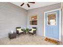 Charming entryway featuring a light blue door, wicker furniture, and neutral tile flooring at 3472 Roanoke St, The Villages, FL 32162