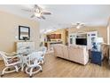 Open-concept living area with light wood floors, ceiling fans, and a comfortable seating arrangement at 3472 Roanoke St, The Villages, FL 32162