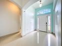 Bright foyer features tile flooring and a front door with sidelights and an arched window at 3731 Peaceful Valley Dr, Clermont, FL 34711
