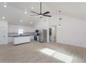 Sun-lit open concept living area with white walls, hard surface floors, and vaulted ceiling at 4817 Cr 686, Webster, FL 33597