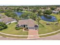 An aerial view of a beautiful home featuring mature trees, lush landscaping, and a serene lake in the background at 4879 Brightmour Cir, Orlando, FL 32837
