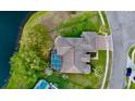 Aerial view of the home, showing the tile roof, screened in pool, and close proximity to a lake at 4879 Brightmour Cir, Orlando, FL 32837