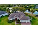 Waterfront home with a brick driveway, mature landscaping, an attached two car garage, and lake views at 4879 Brightmour Cir, Orlando, FL 32837
