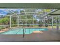 A screened-in pool area provides clear views of the backyard, pond, and neighborhood at 4879 Brightmour Cir, Orlando, FL 32837