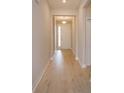 Inviting hallway with light wood-look flooring leading to the front door with sidelights at 5006 Abigail Dr, Lake Wales, FL 33859