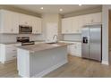 Bright kitchen with white cabinets, stainless steel appliances, kitchen island, and modern finishes at 5006 Abigail Dr, Lake Wales, FL 33859