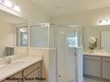 Modern bathroom featuring double vanity sinks, a framed mirror, and a glass-enclosed shower at 524 Silver Palm Dr, Haines City, FL 33844