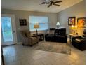 Cozy living room with neutral decor, comfortable seating and natural lighting from a window and glass door at 529 Del Mar Dr, Lady Lake, FL 32159