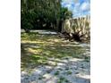 Spacious yard with lush trees and a partially visible fence, partially shaded, showing a serene outdoor area at 5809 County Road 547 N, Davenport, FL 33837