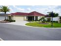 Beautiful single-story home with a lush front lawn, mature landscaping, and a spacious driveway at 664 Mission Hills Trl, The Villages, FL 32162